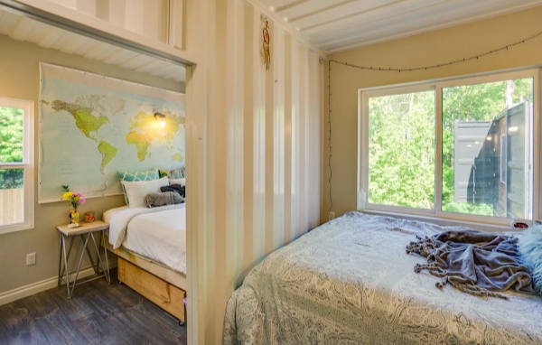 Bedroom with a large window, bed, and world map on the wall.