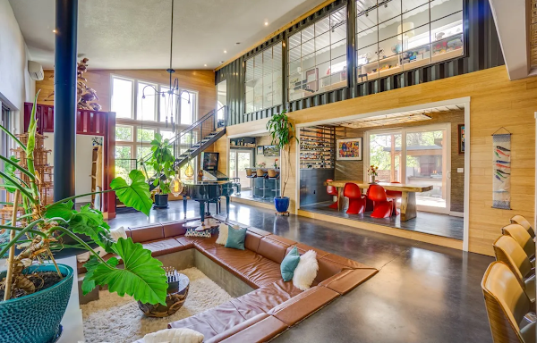 Modern living room with large windows, wooden floor, and decorative elements.