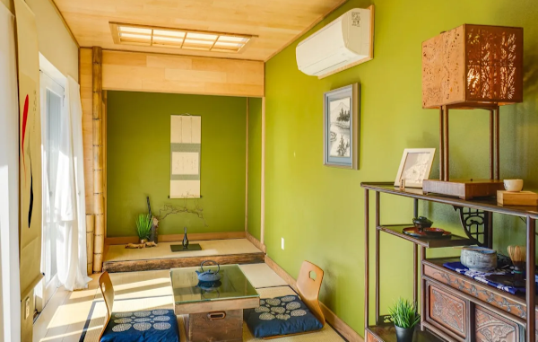 Japanese-style room with green walls, tatami mats, and traditional decor.