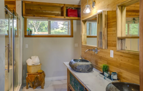 Bathroom with wooden walls, sink, and window