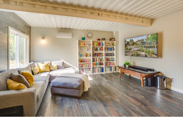Living room with a sectional sofa, bookshelf, and TV