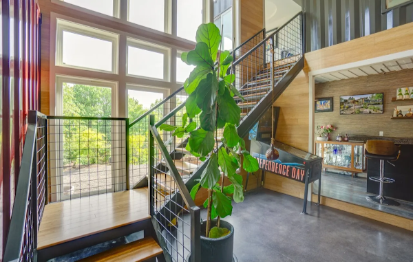 Modern interior with a staircase, large plant, and wall art.