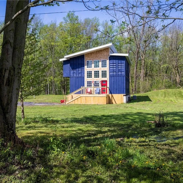 Small blue and brown cabin in a forested area