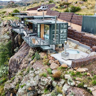 Modern house built into a cliffside with a scenic mountain view.