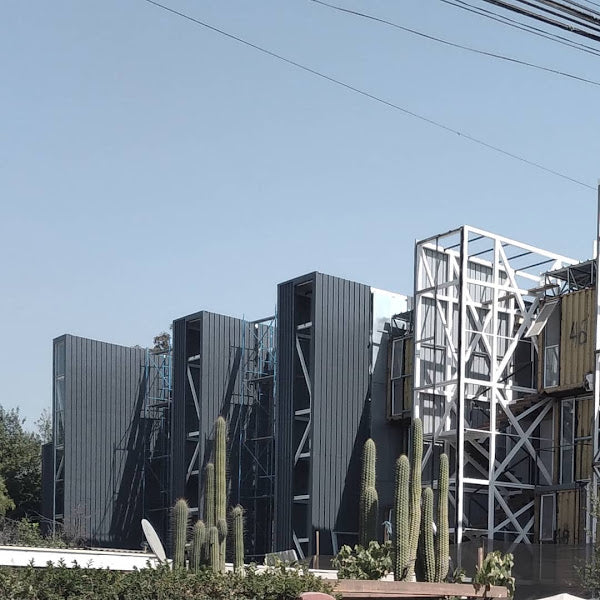 Modern architectural structure with geometric design, featuring cacti in the foreground.