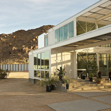 Modern building with large glass windows and a mountainous landscape in the background