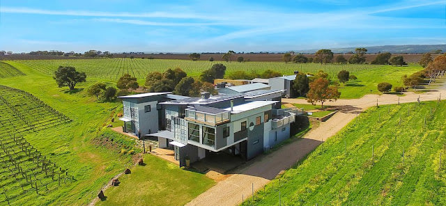 Modern house in a rural setting with green fields and trees