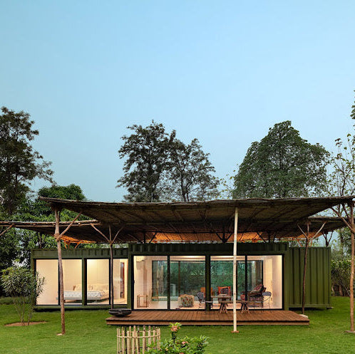 Modern house with a green roof and glass walls surrounded by trees