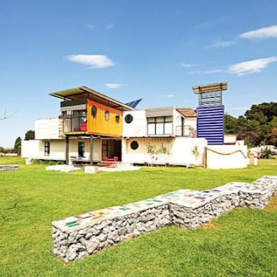 Modern house with colorful design in a grassy field under a blue sky